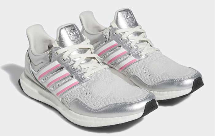 View of silver, white, and pink adidas shoes.